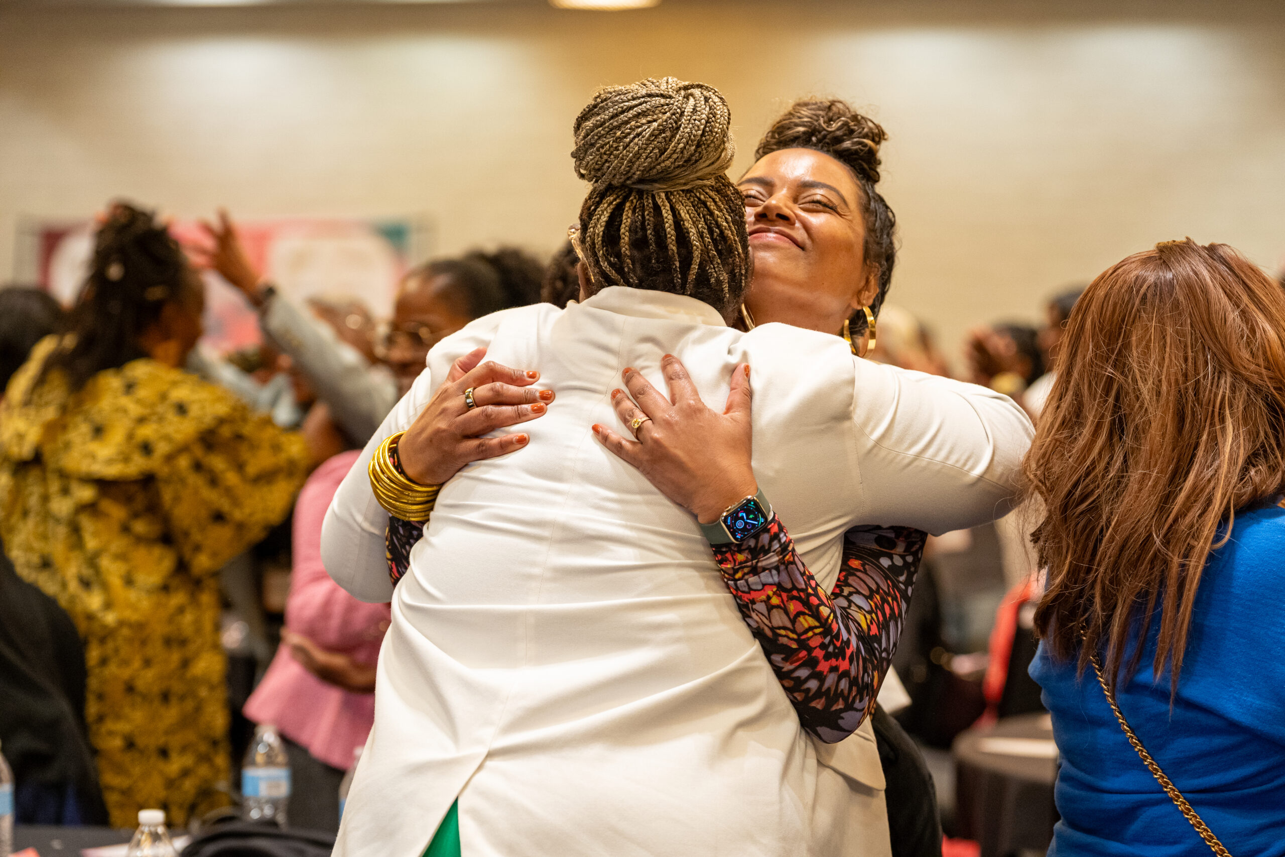 Two women hugging at the Black Women’s Health Forum, a community event advancing Black women’s health equity in California